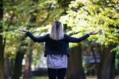 lady in forest with her arms up